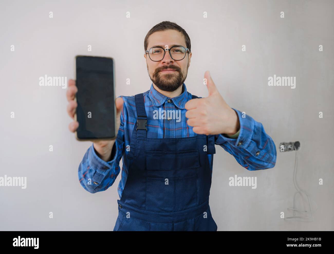 young man in blue work suit doing Repair apartment. Home renovation ...