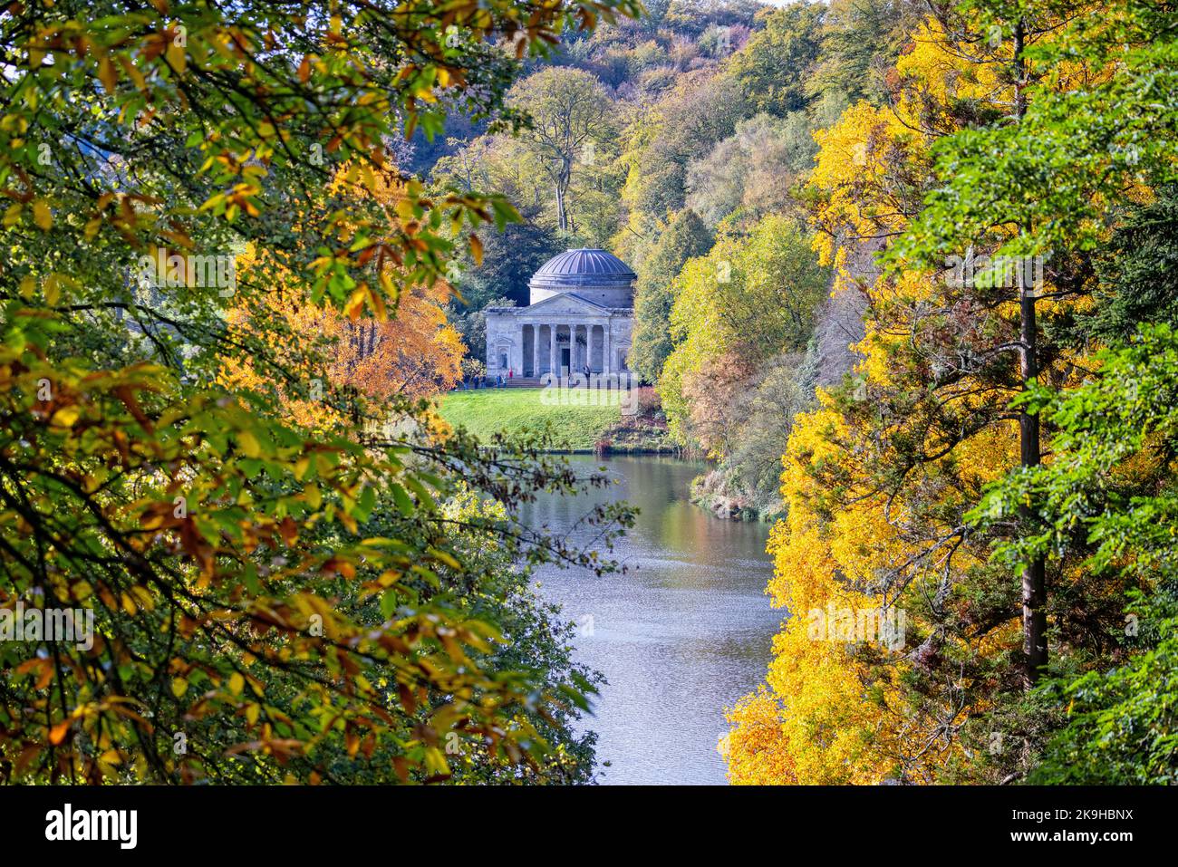 The Temple of Flora at Stourhead framed by trees and foliage in golden autumn colours at Stourton, Wiltshire, UK on 28 October 2022 Stock Photo