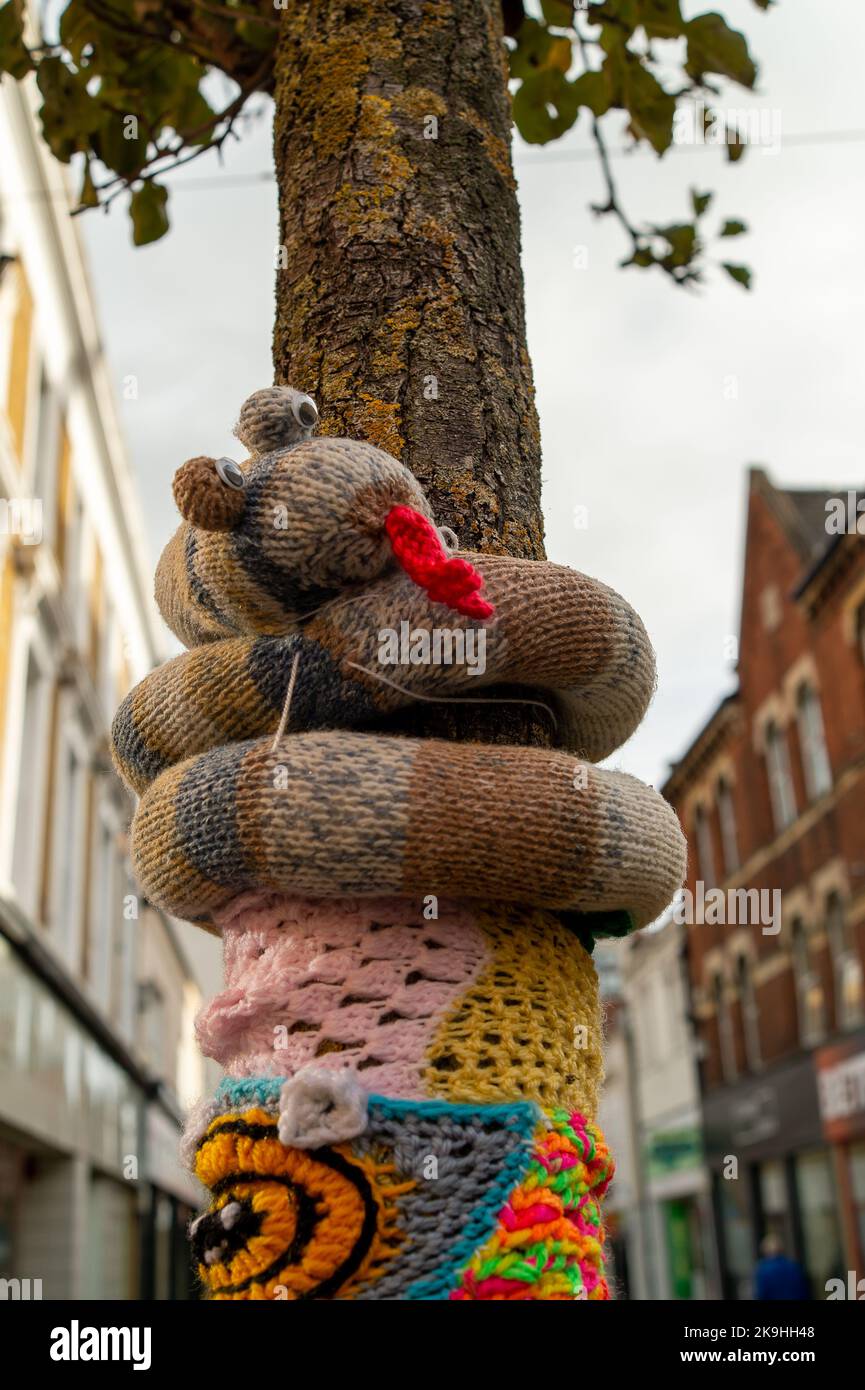 Maidenhead, Berkshire, UK. 28th October, 2022. Cheery Autumnal knitted and  crochet post box toppers have appeared on post boxes in Maidenhead High Street. Trees next to the old post office also have crochet scarves and a snake wrapped around them.  Made by 'yarn bombers' they are loved by people young and old. Credit: Maureen McLean/Alamy Live News Stock Photo