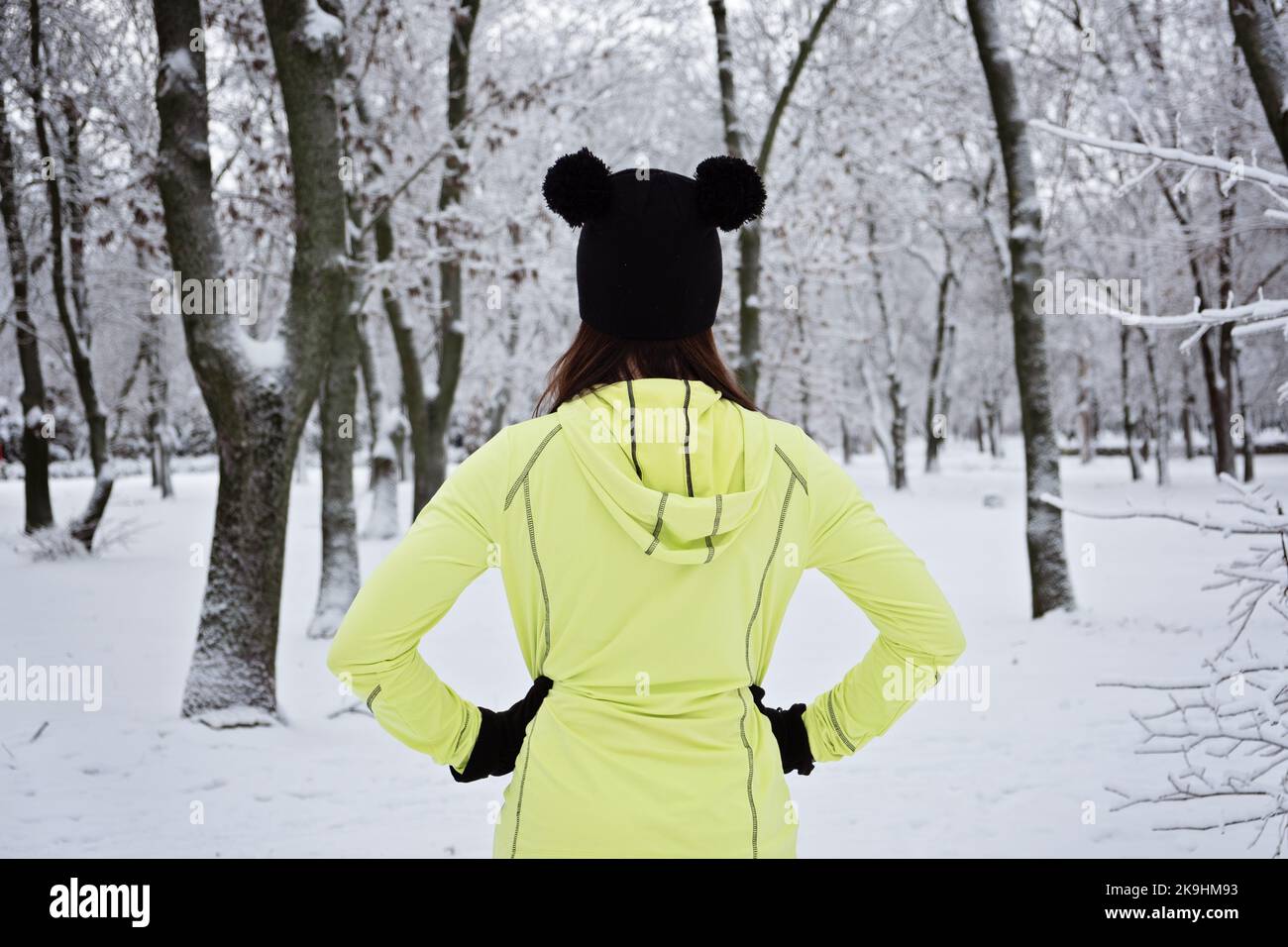 Back view of Woman ready to winter workout outdoor exercise in snowy
