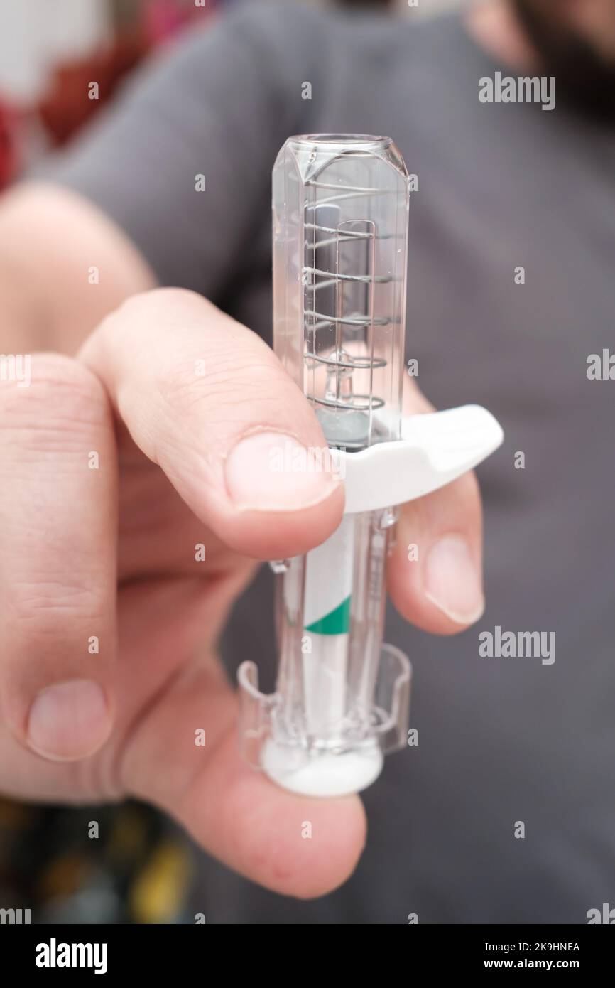 Safe syringe in the hand, with spring mechanism to retract the needle