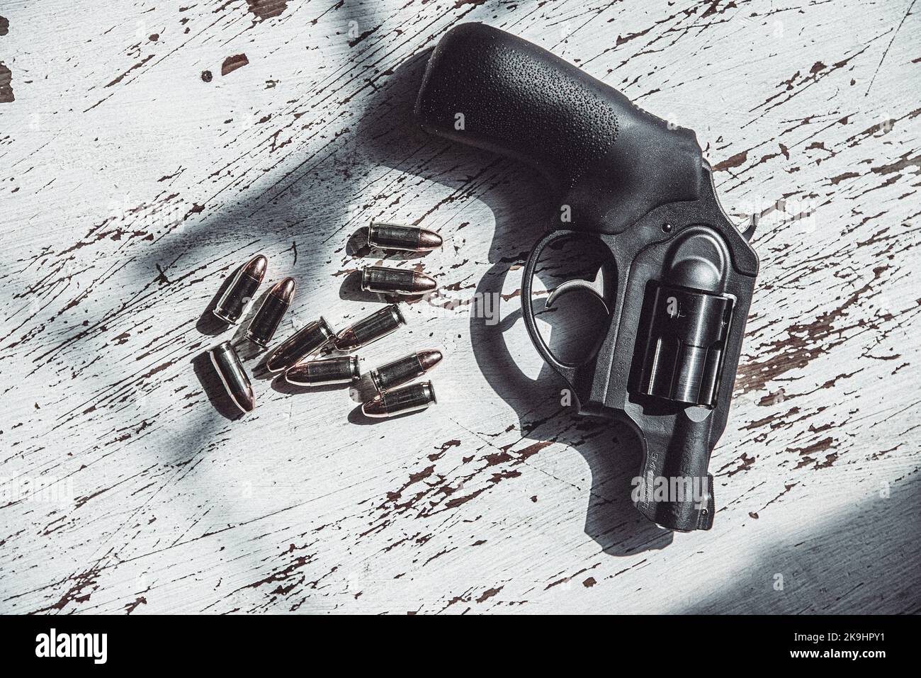 A black, Ruger, 9mm, snub-nosed revolver along with a grouping of 9mm bullets. Stock Photo