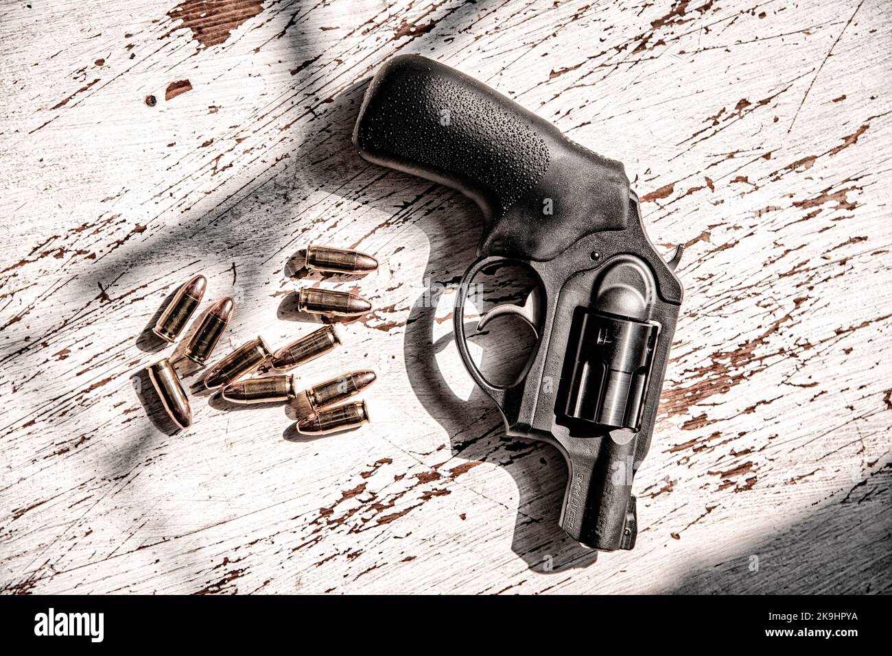 A black, Ruger, 9mm, snub-nosed revolver along with a grouping of 9mm bullets. Stock Photo