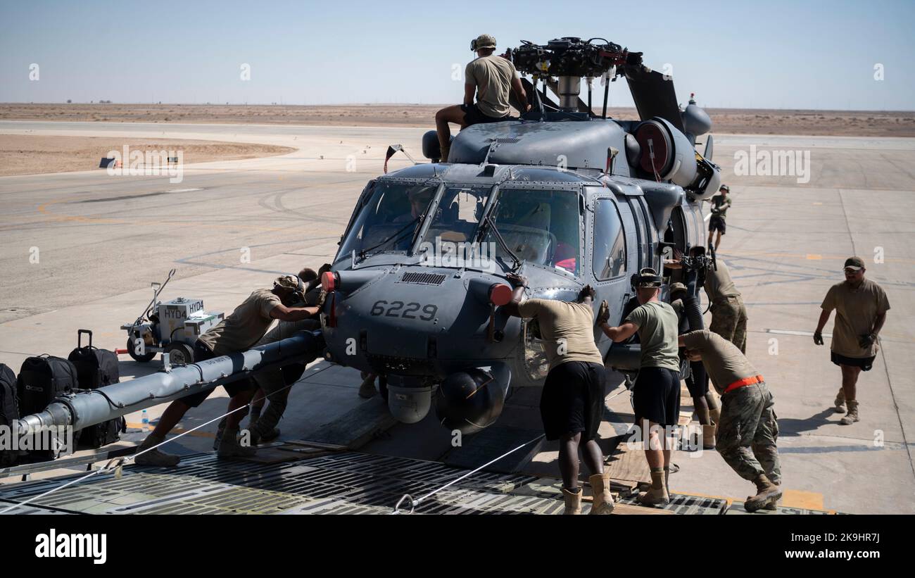 Airmen from the 1st Expeditionary Rescue Group and the 60th Air Mobility Wing, Travis Air Force Base., unload an HH-60 Pave Hawk helicopter from a C-5M Galaxy at an undisclosed location, Southwest Asia, Oct. 11, 2022. The primary mission of the Pave Hawk is to conduct personnel recovery operations into hostile environments to recover isolated personnel during war. (U.S. Air Force photo by Tech. Sgt. Jeffery Foster) Stock Photo