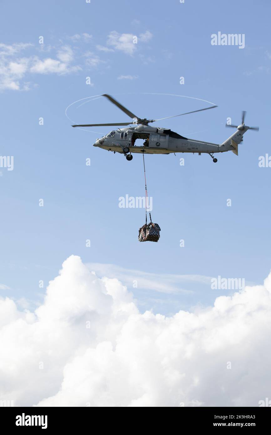 An MH-60S Seahawk, assigned to the 'Chargers' of Helicopter Sea Combat Squadron 26, carries cargo to the airfield on Puerto Barrios Marine Base, Oct. 27, 2022. Comfort is deployed to U.S. 4th Fleet in support of Continuing Promise 2022, a humanitarian assistance and goodwill mission conducting direct medical care, expeditionary veterinary care, and subject matter expert exchanges with five partner nations in the Caribbean, Central and South America. (U.S. Army Photo by Cpl. Genesis Gomez) Stock Photo