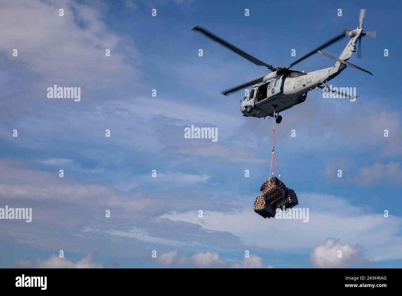 221026-N-VQ841-2014 GUATEMALA (Oct. 26, 2022) An MH-60S Seahawk, assigned to the 'Chargers' of Helicopter Sea Combat Squadron 26, carries cargo to the coast of Puerto Barrios, Guatemala, after the hospital ship USNS Comfort's (T-AH 20) arrival, Oct. 26, 2022. Comfort is deployed to U.S. 4th Fleet in support of Continuing Promise 2022, a humanitarian assistance and goodwill mission conducting direct medical care, expeditionary veterinary care, and subject matter expert exchanges with five partner nations in the Caribbean, Central and South America. (U.S. Navy photo by Mass Communication Special Stock Photo