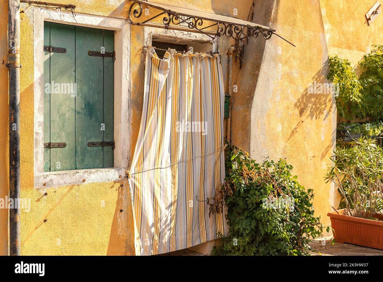The traditional yellow wall with window and door on the Burano Island in Venice, Italy Stock Photo