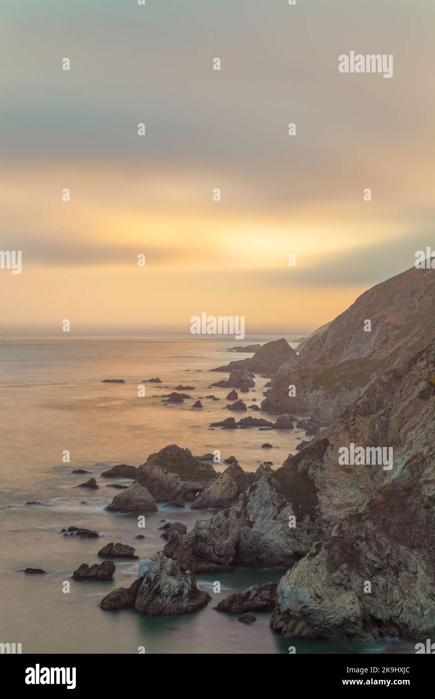 The image captures a breathtaking coastal landscape bathed in the soft ...