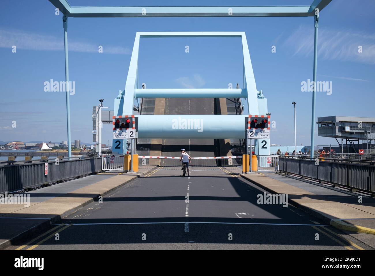 Cyclist waiting at the opening of the Bascule Bridge at the Cardiff Bay Barrage in Cardiff South Wales UK Stock Photo