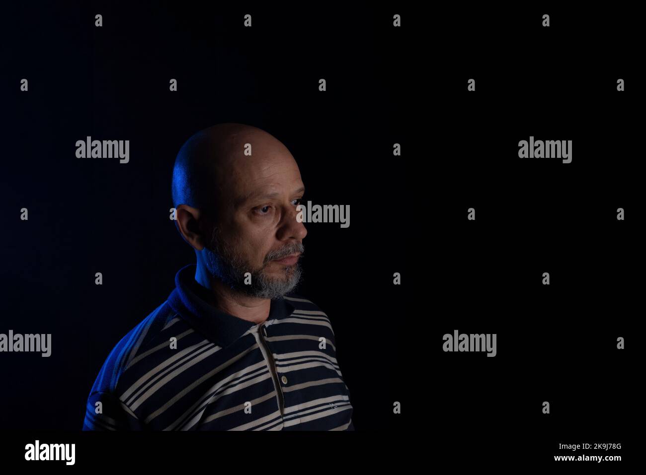 Young handsome bald man with beard wearing casual shirt over black background. Thinking worried. Thoughtful. Stock Photo