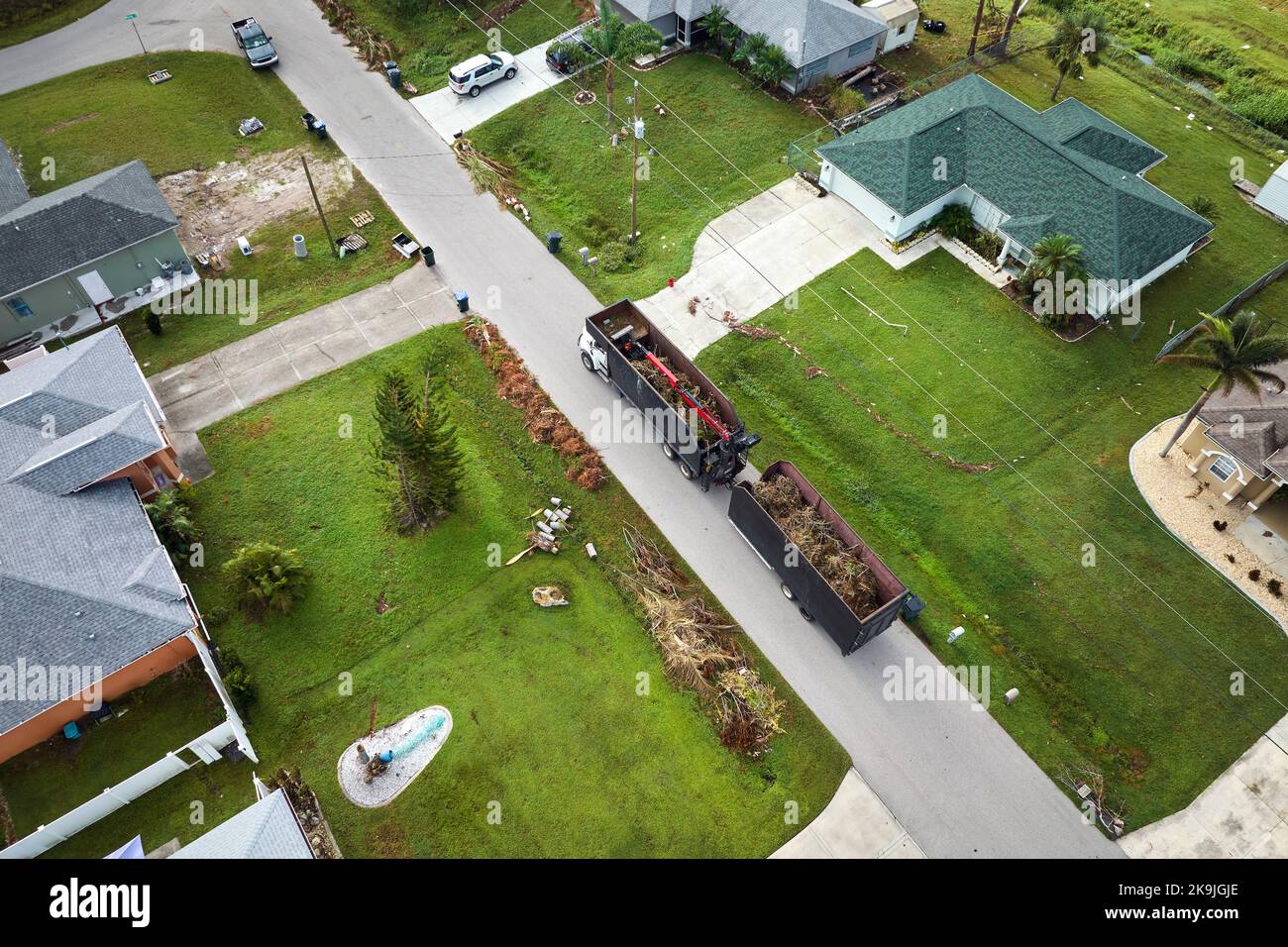 Special aftermath recovery dump truck picking up vegetation debris from