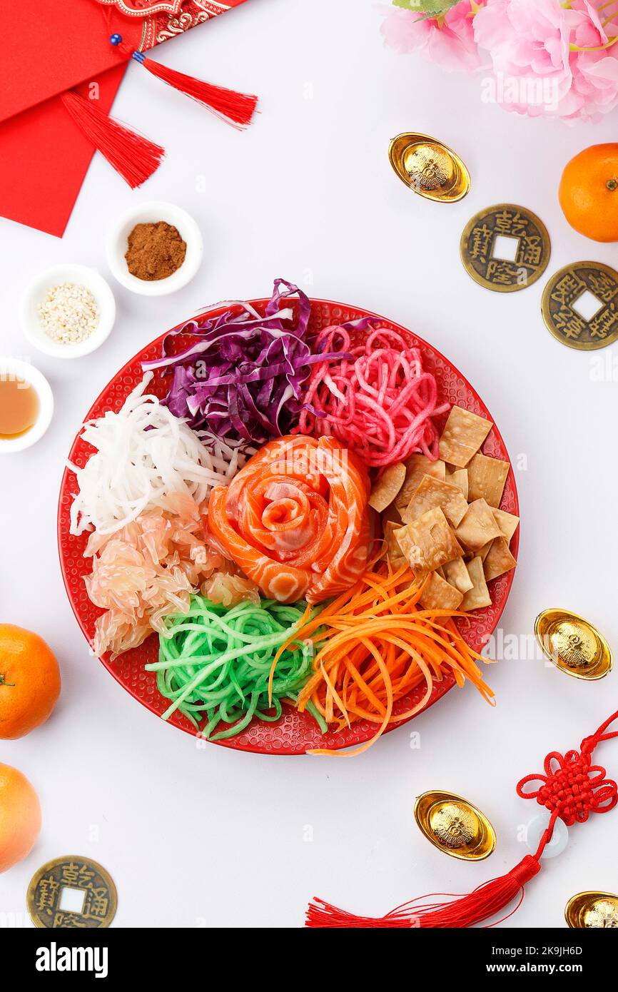 Yee Sang, Yusheng, Lo Hei, or Lou Sang is Cantonese Style Raw Fish Salad. It is Symbol of Abundance, Prosperity, and Vigor. Chinese Raw Salad Stock Photo