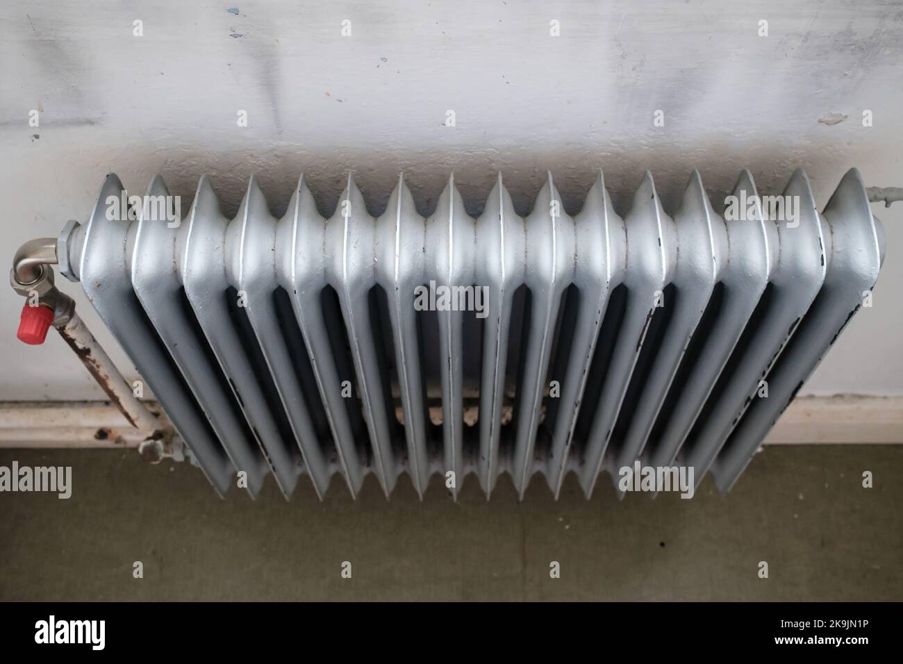 Old radiator with a valve that turns the heating on or off. Energy