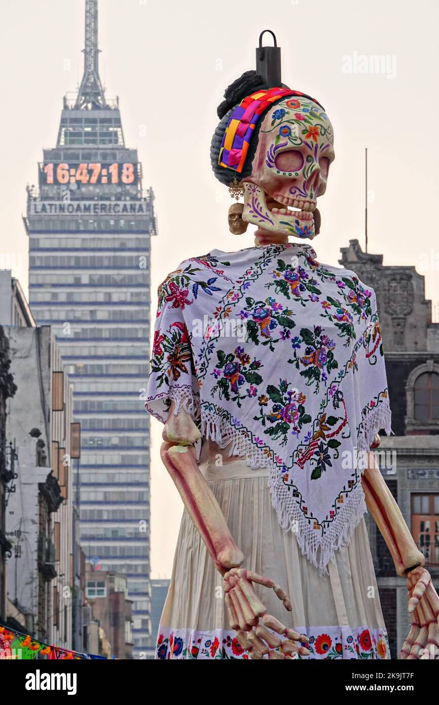 Mexico City, Mexico. 28th Oct, 2022. A giant sculpture of Catrina, the skeleton bride, appears as tall as the Latin American Tower during the Megaofrenda of Zocalo festival to celebrate the start of the Day of the Dead holiday at the Plaza de la Constitucion, October 28, 2022 in Mexico City, Mexico. Credit: Richard Ellis/Richard Ellis/Alamy Live News Stock Photo