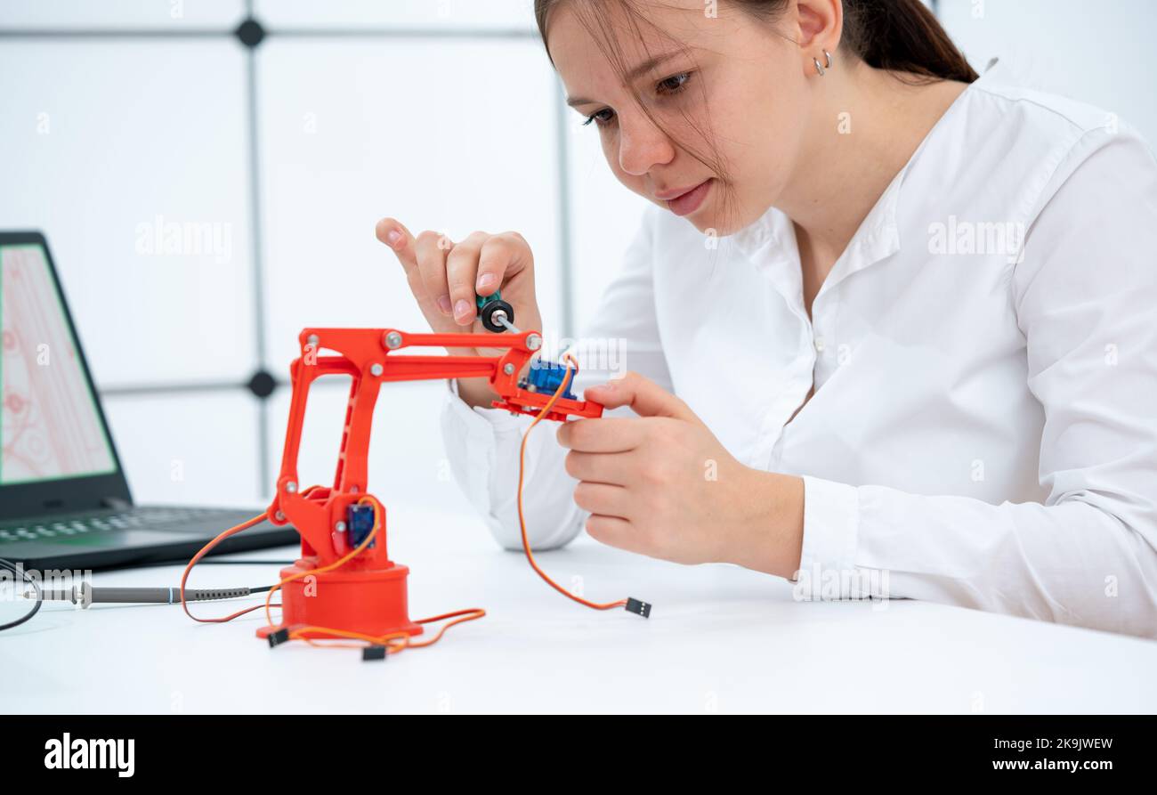 Student Project Using Printed schoolgirl student experimenting with a 3D printed robot model Stock ...