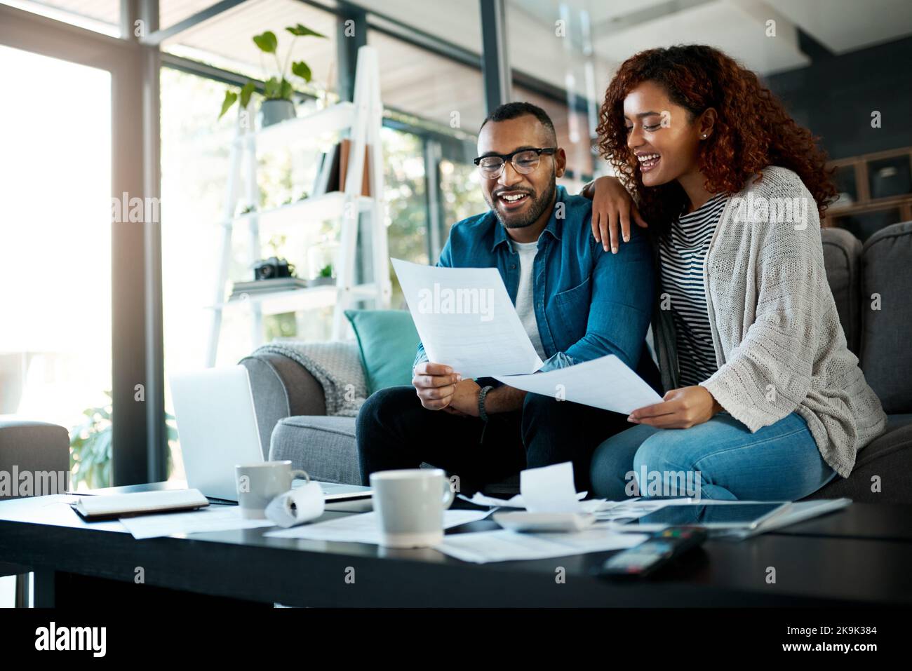 They keep an account of everything. a young couple planning their budget together at home. Stock Photo