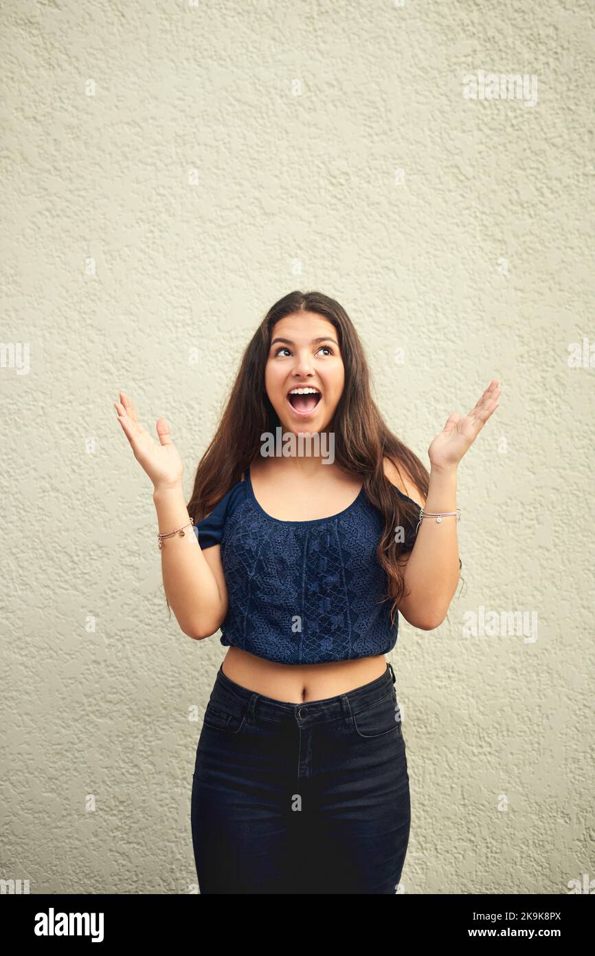 Im young, wild, free and just being me. Portrait of a happy teenage girl posing against a wall outside. Stock Photo