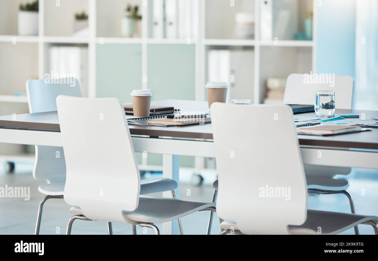 Interior, meeting and empty office for a presentation with a table, chairs and paperwork for a corporate audience. Startup, conference room and Stock Photo