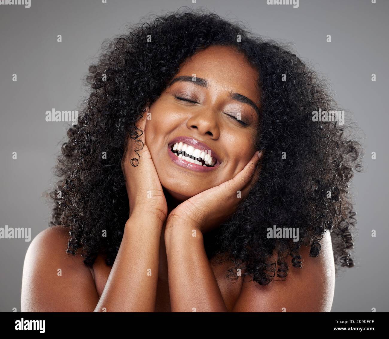 Black woman, skincare model with smile in studio against grey wall background with happiness. Plus size beauty, happy cosmetic woman with glow skin Stock Photo