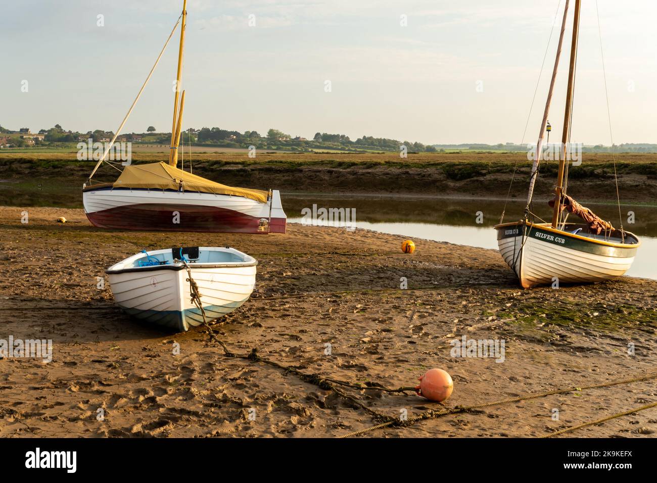 Boats at rest in Blakeney, Norfolk, on a sunny evening at low tide