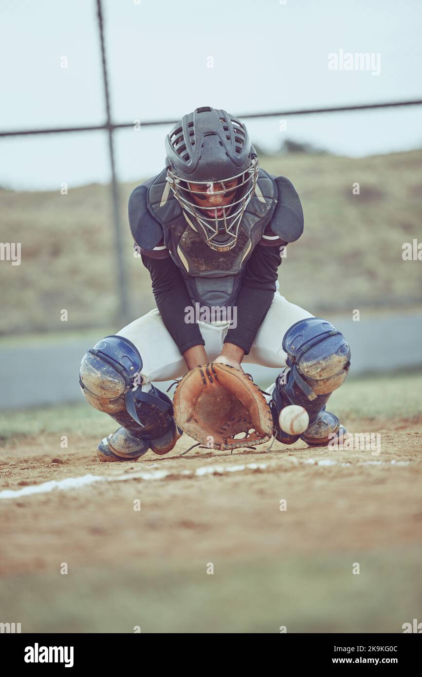 Baseball, sports and ball with a catcher on a grass pitch or field ...