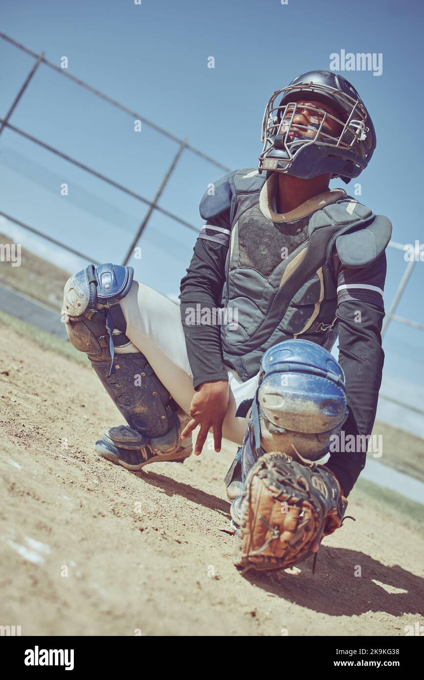 Sports, baseball and catcher ready in a game, match or training on outdoor baseball field. Fitness, exercise and baseball player with focus Stock Photo