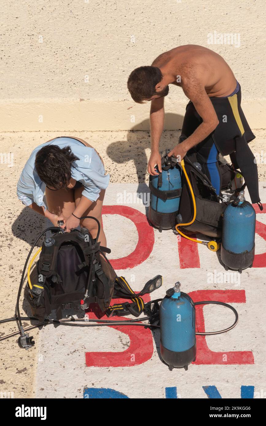 Agios Nikolaos, Crete, Greece. 2022. Couple at dive school preparing equipment to go diving. Stock Photo