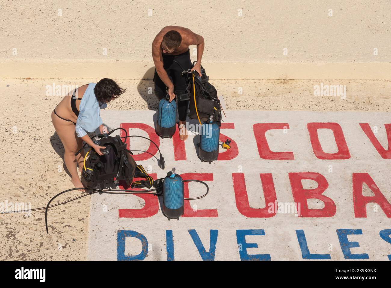 Agios Nikolaos, Crete, Greece. 2022. Couple at dive school preparing equipment to go diving. Stock Photo