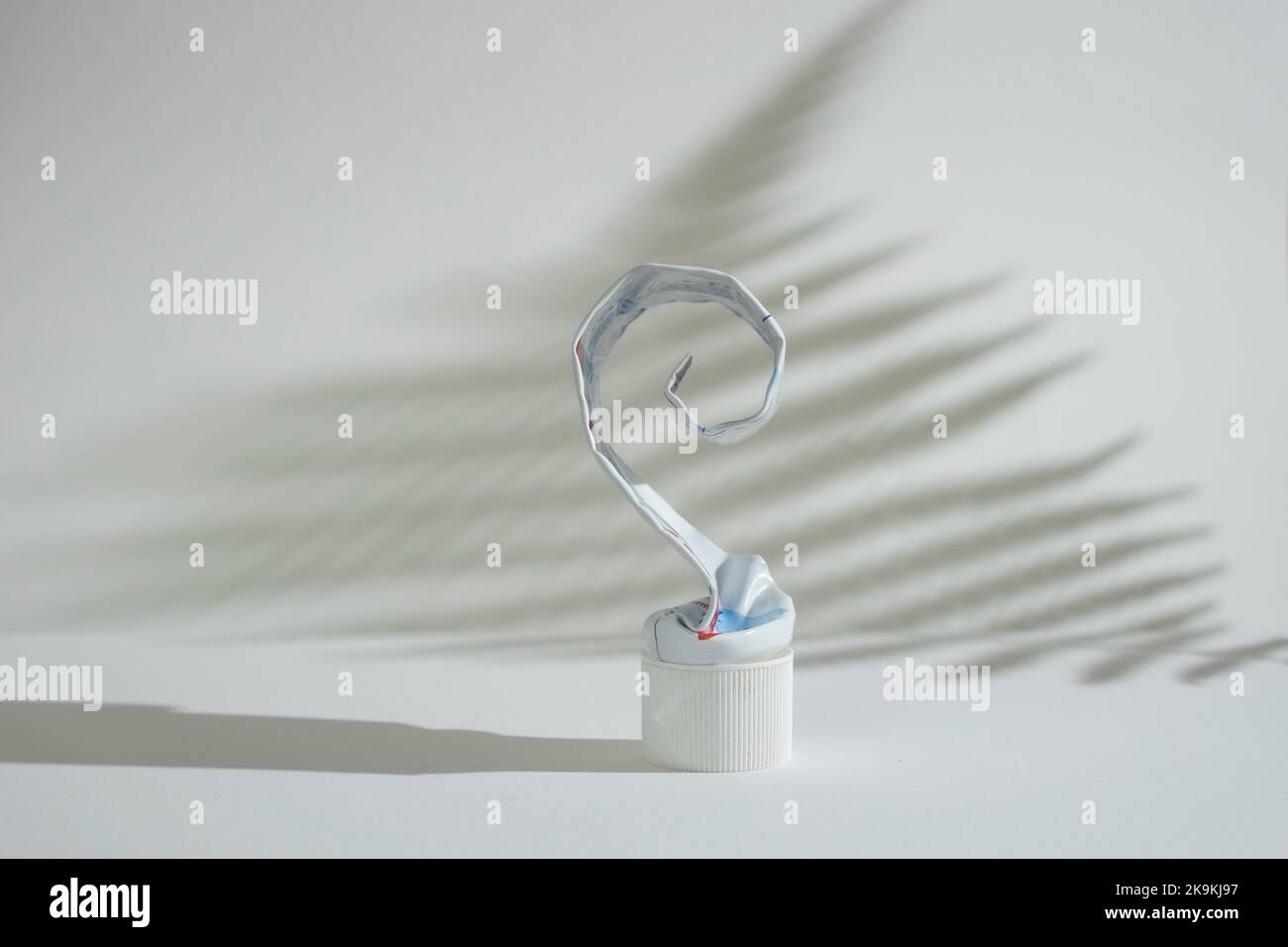 Empty aluminum toothpaste container tube, squeezed and rolled, side