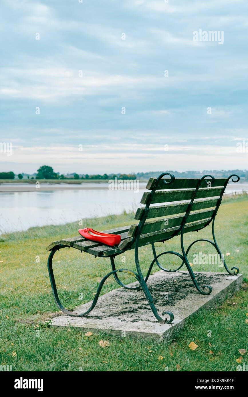 Pair of red shoes on park bench. Stock Photo