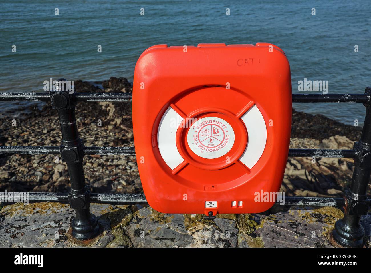 A bright red life saving float on railings beside the South West Coast Path at Mount Batten in Plymouth Stock Photo