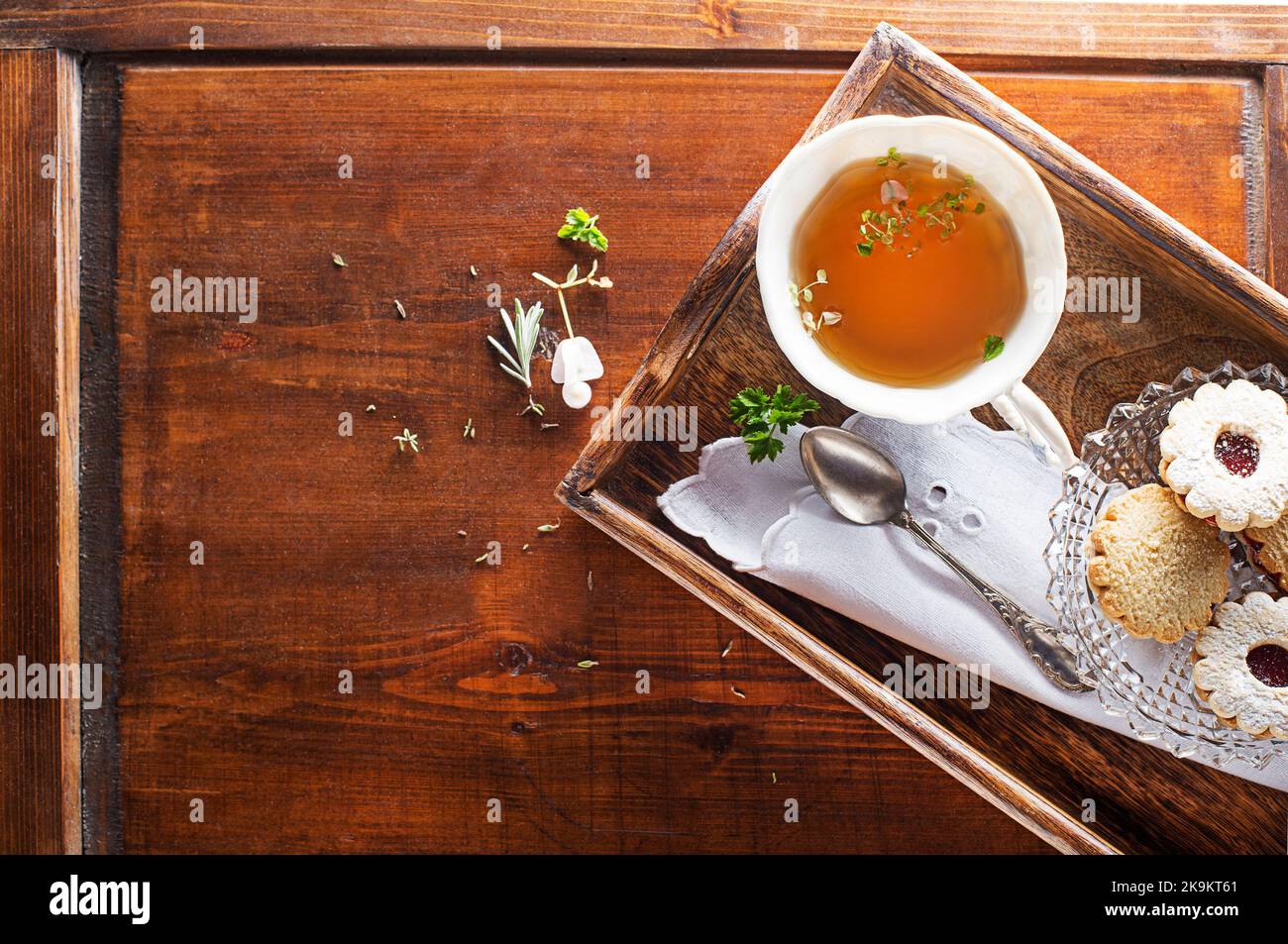 Tea Cup with of fresh herbal leaves and cookies on wooden background, top view, place for text. Healthy concept Stock Photo