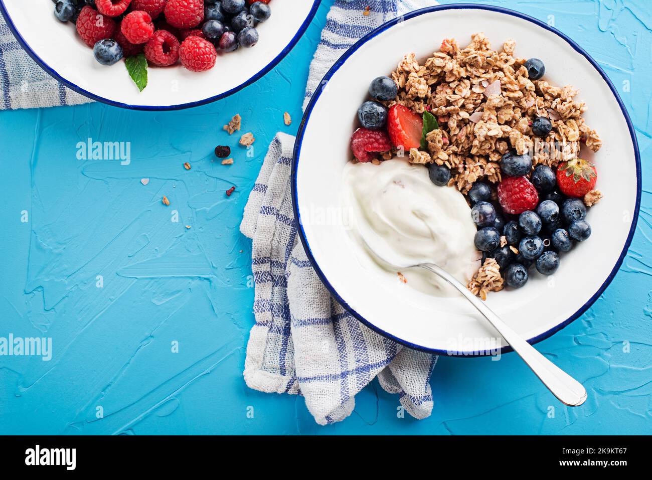 A plate of dry granola served with fresh berry fruit and yogurt. Oatmeal plate. Healthy food, diet. Top view. Stock Photo