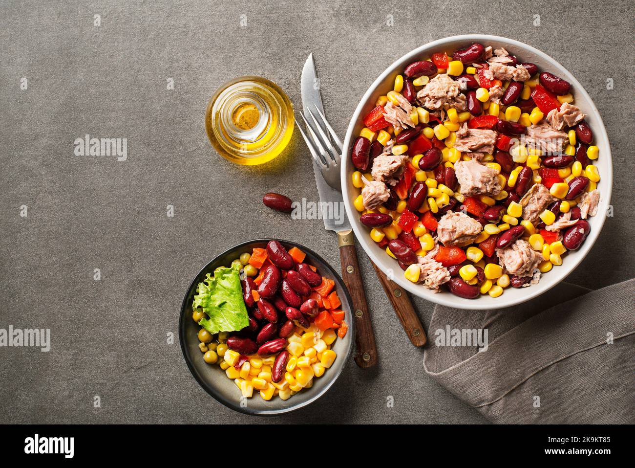 Healthy tuna salad with corn, peppers and beans on grey background. Mexican corn salad. Stock Photo