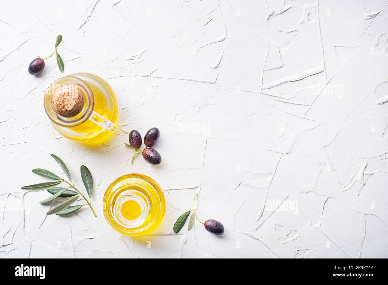 Olive oil bottles with olives and olive branch on white background Stock Photo
