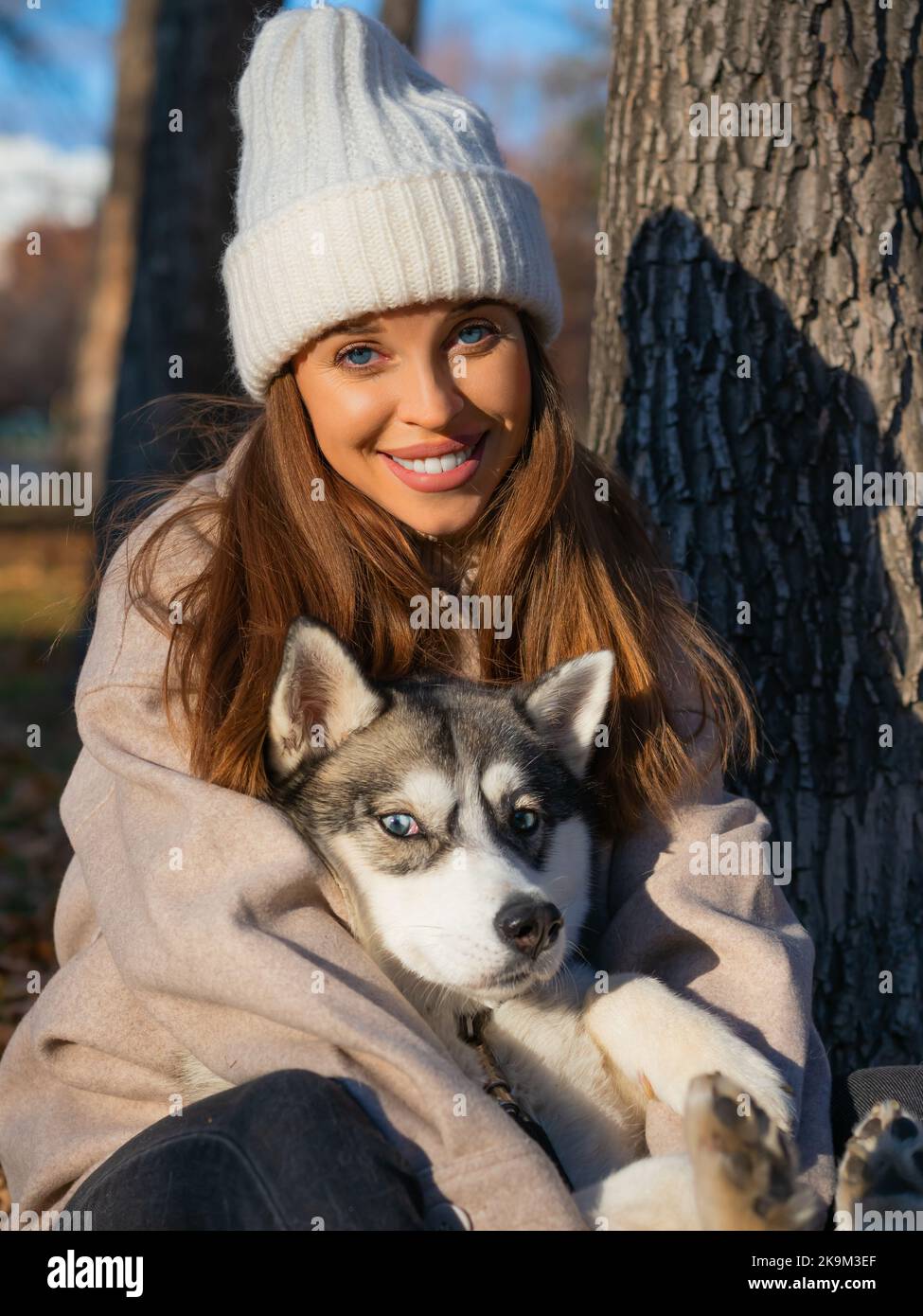 Young woman embracing her dog and looking at camera. The concept of