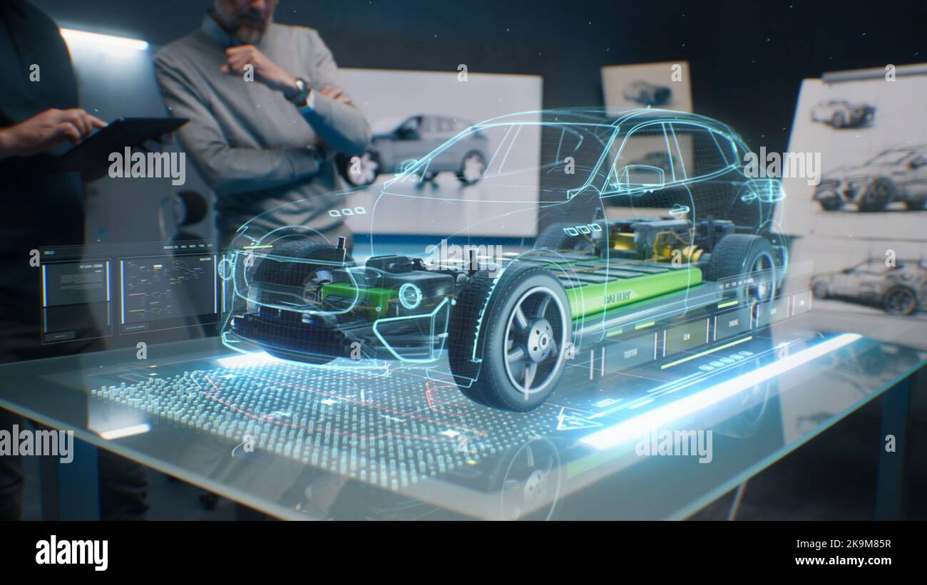 Car design engineers using holographic app in digital tablet. Develop modern innovative high-tech cutting edge eco-friendly electric car with sustainable standards. They test the aerodynamic qualities Stock Photo