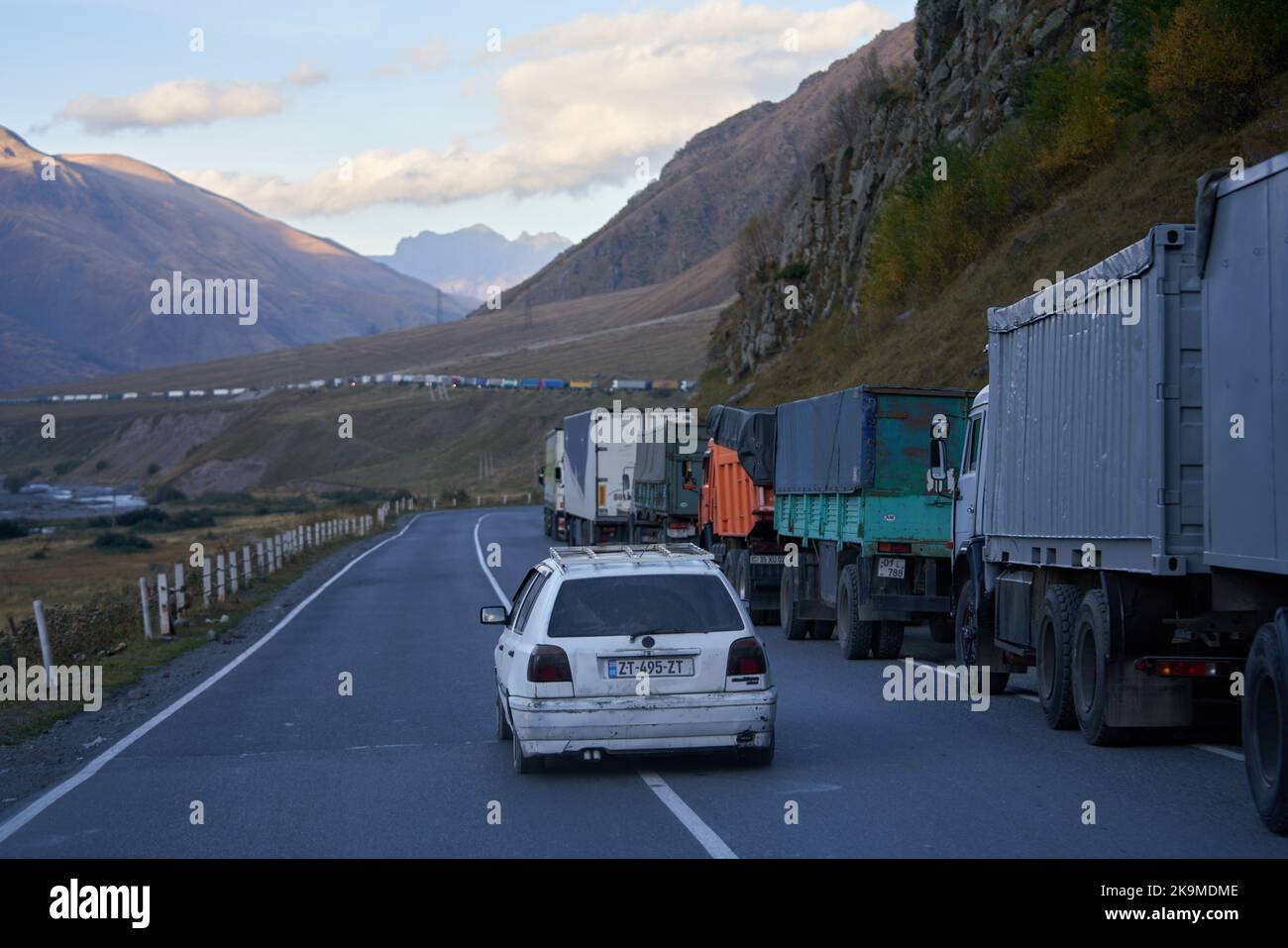 Kazbegi, Georgia - October 2, 2022: Several kilometres long line of Trucks by the side of the Georgian military highway near Kazbegi waiting for cross Stock Photo