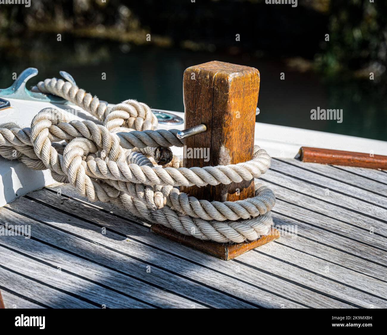 Rope tied around mooring post on the quayside. Stock Photo