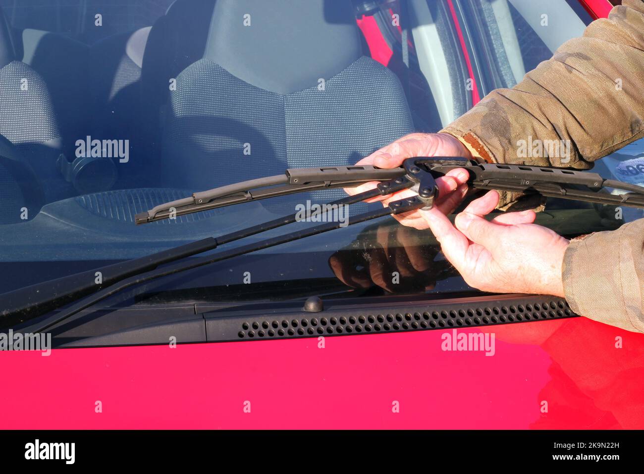 Man fitting a new windscreen wiper blade to his car. replacing the worn