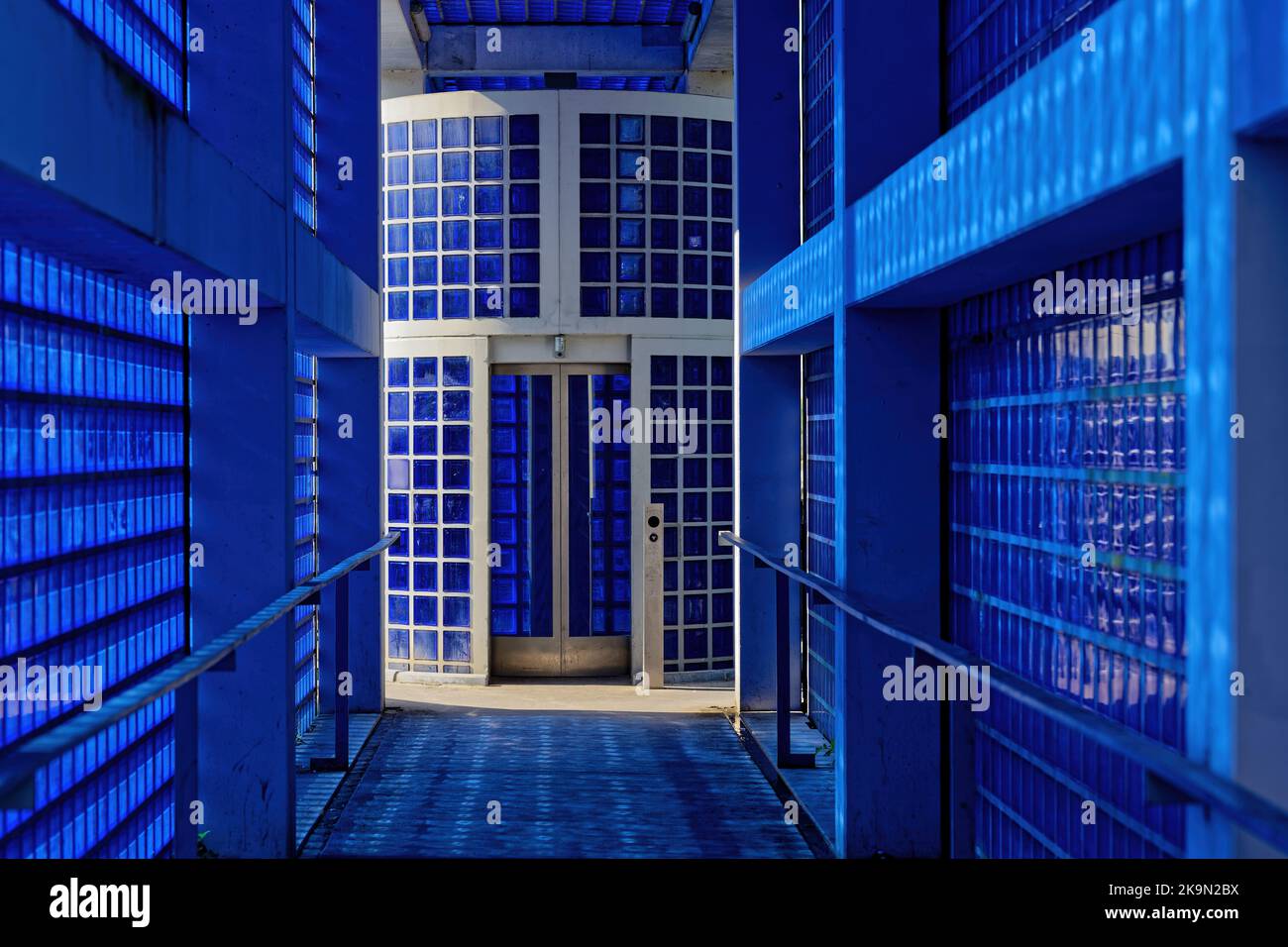 Blue colored glass block corridor and elevator door Stock Photo