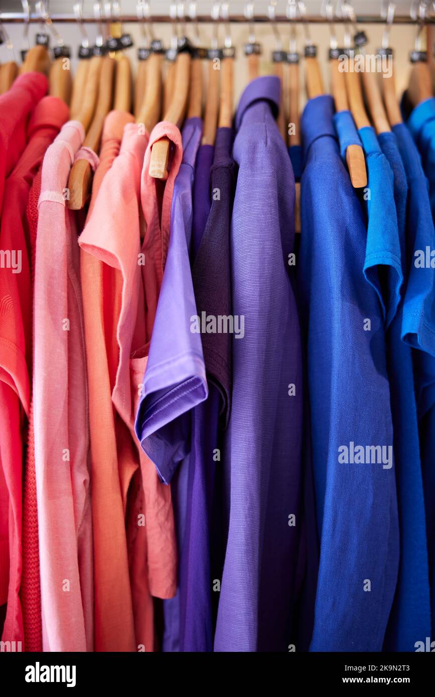 Colourful Sustainable Clothing Hanging On Rail In Charity Or Thrift Store Selling Sustainable Fashion Stock Photo