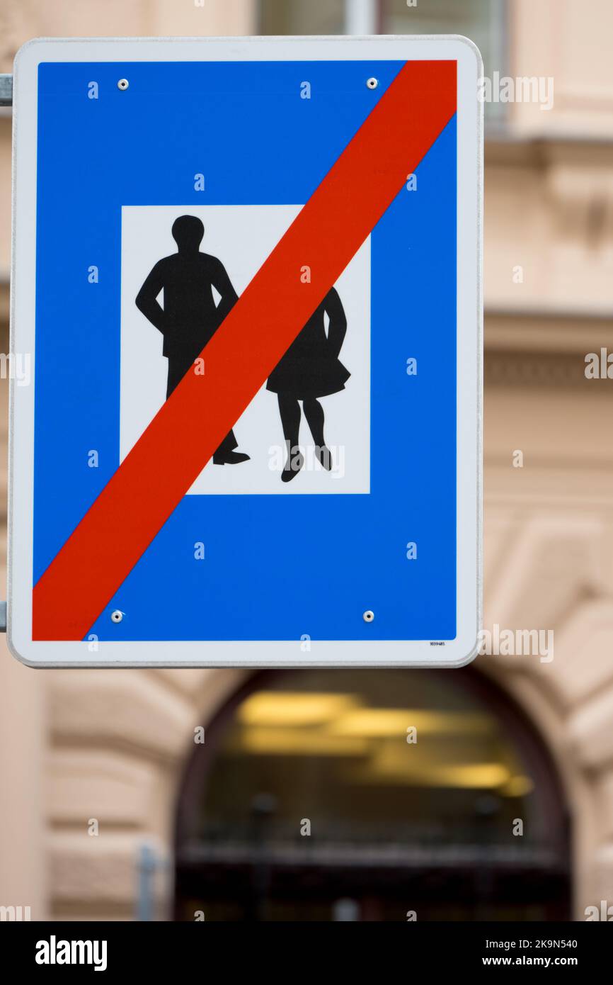 Closeup of a traffic sign blue billboard with red line across a man