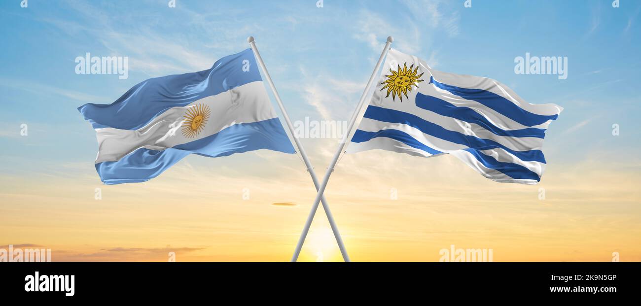 crossed national flags of Argentine and Uruguay flag waving in wind at ...