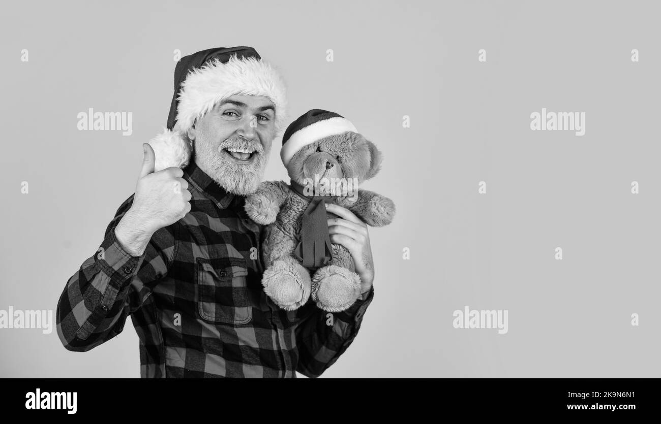 Kind hipster with teddy bear. Charity and kindness. Lovely hug. Santa Claus. Mature man with long beard. Christmas spirit. Christmas time for mercy Stock Photo
