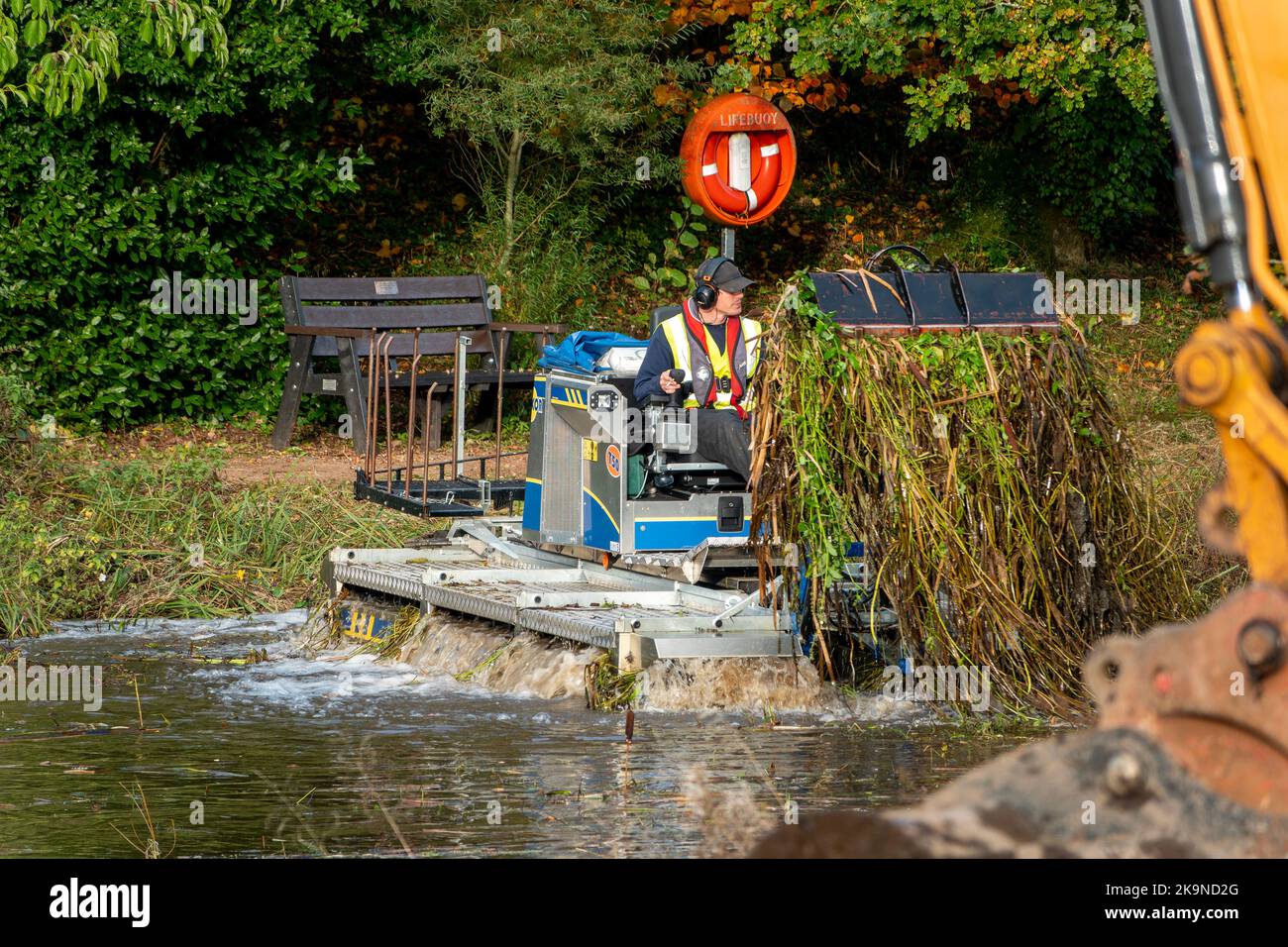 A small dredger clearing out a small lake in Wales Stock Photo