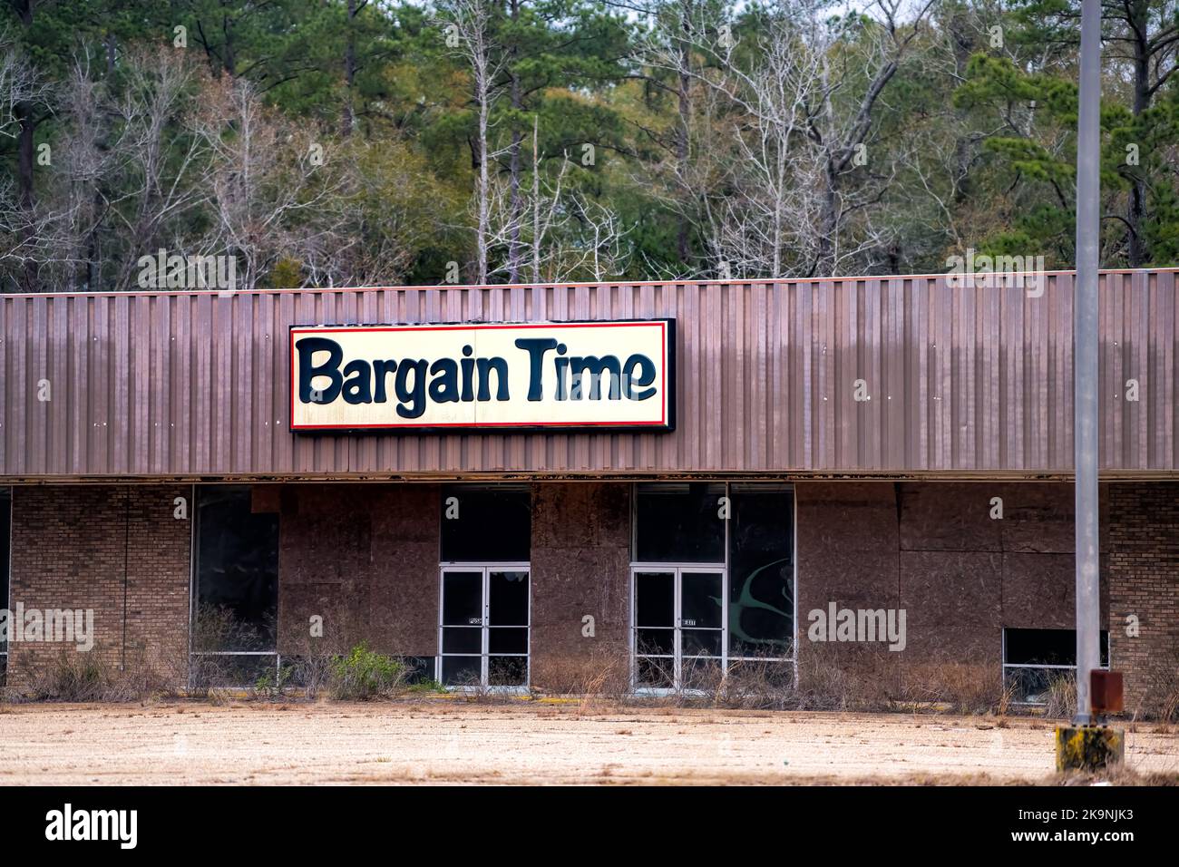 Old delapidated abandoned shopping strip mall with bargain time store closed or bankrupt in suburb small rural city of Jack, Alabama Stock Photo