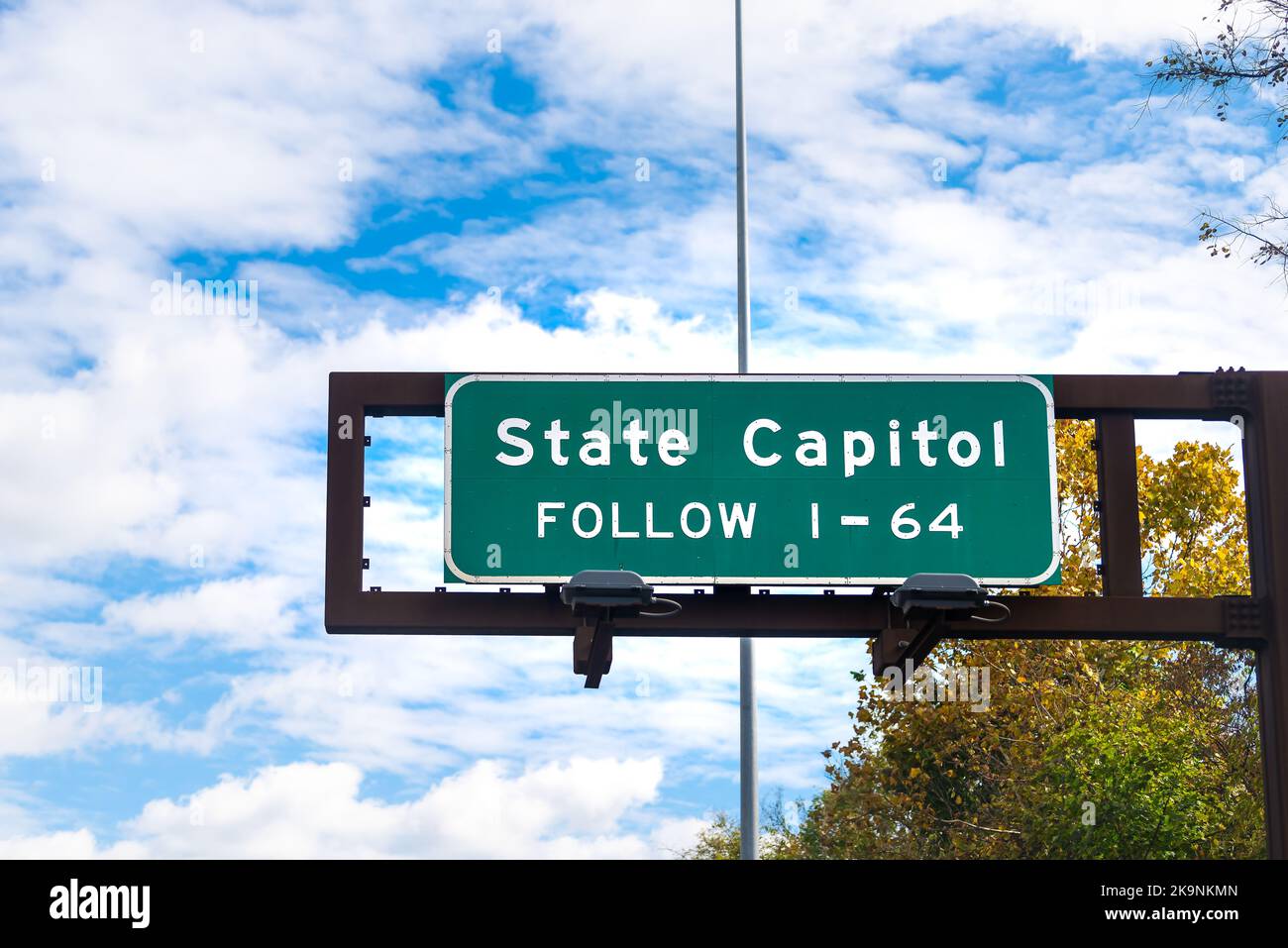 Closeup of interstate highway 64 road sign for state capitol legislature in Charleston, West Virginia in autumn fall with blue sky clouds Stock Photo