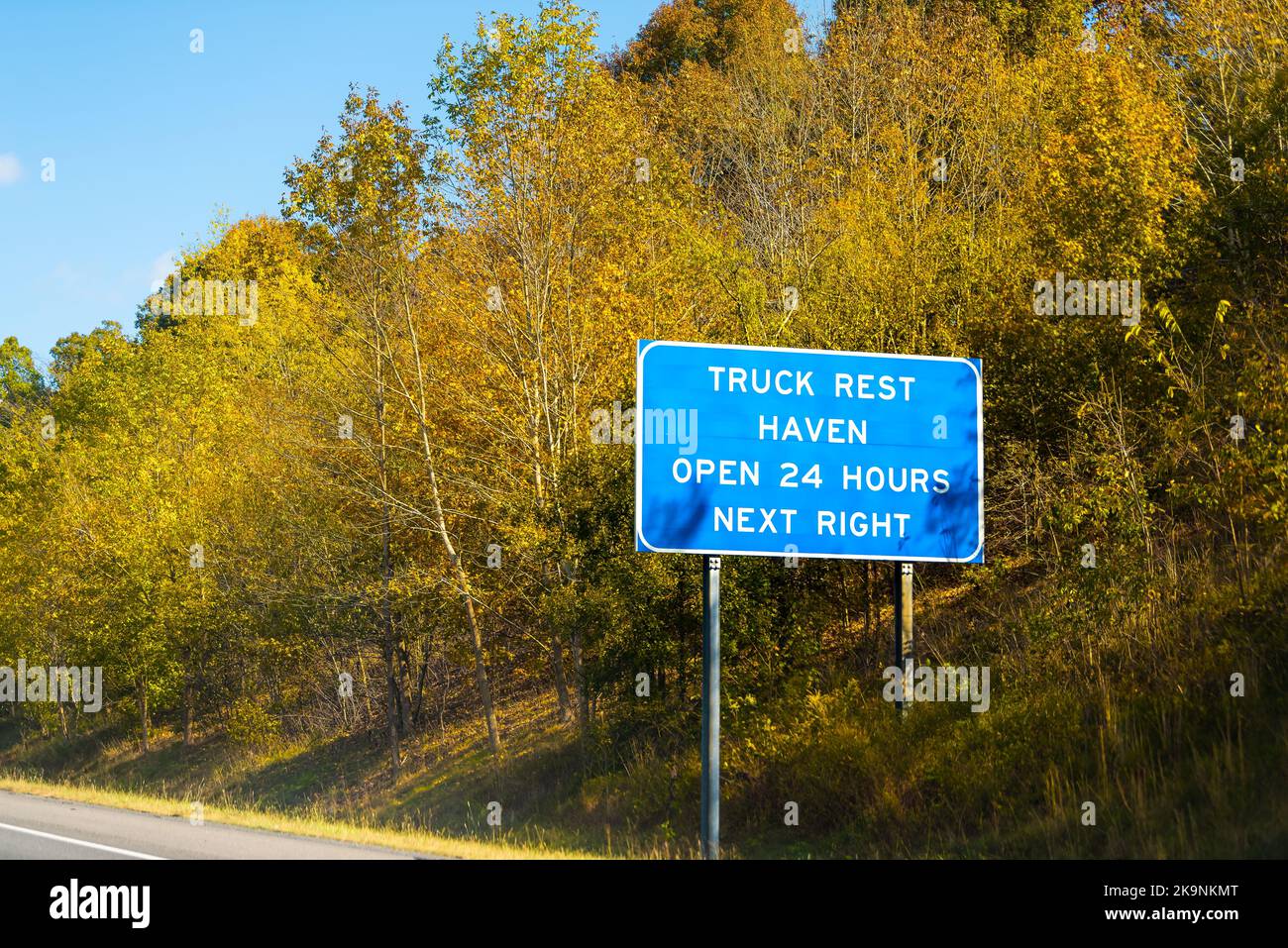 Road highway sign for truck stop rest area haven open 24 hours with exit blue sign in rural