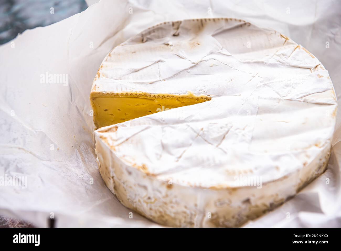 French soft brie cheese round wheel in paper package, dairy double